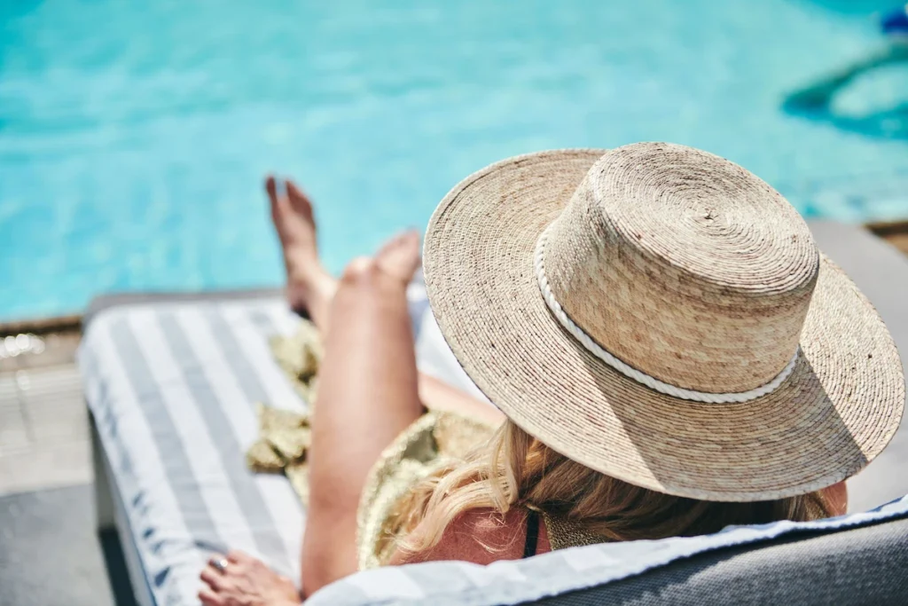 Woman relaxing poolside at Pendry Nashville, showcasing the resort-style amenities available at these luxury condos for sale.